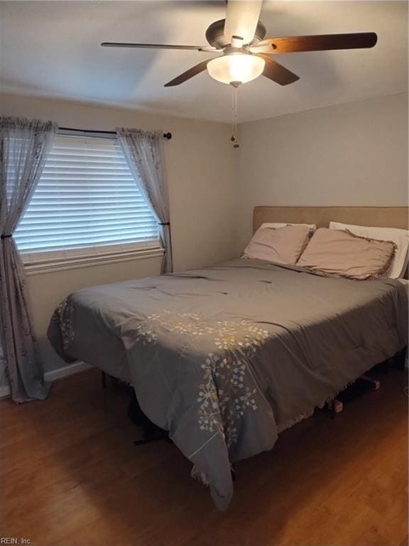 bedroom with ceiling fan and dark hardwood / wood-style flooring