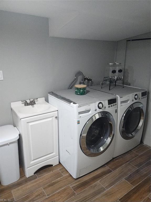 washroom featuring washing machine and clothes dryer, sink, and cabinets