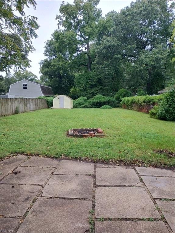 view of yard featuring a storage shed and a patio