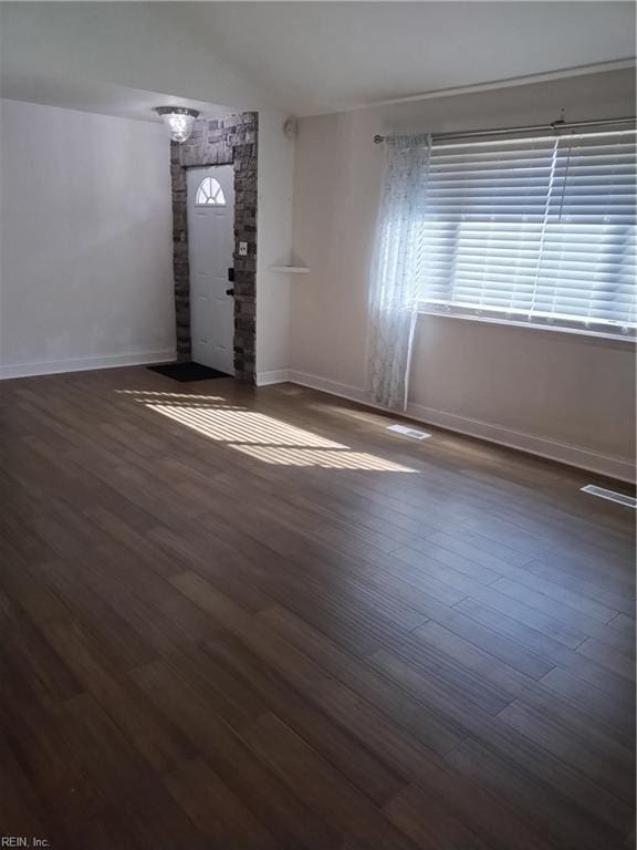 entrance foyer with dark hardwood / wood-style flooring and lofted ceiling