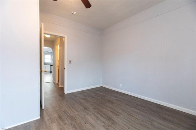 spare room featuring ceiling fan and dark wood-type flooring