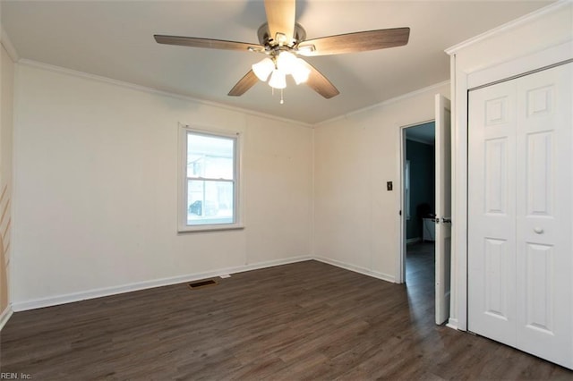 unfurnished room with crown molding, ceiling fan, and dark wood-type flooring