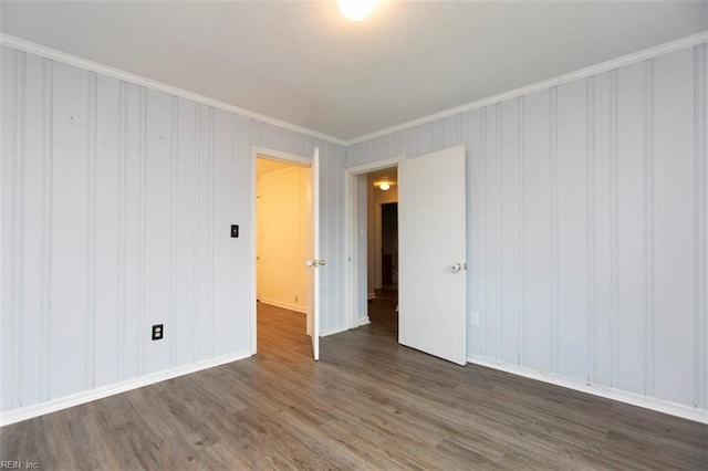 empty room featuring ornamental molding and dark wood-type flooring