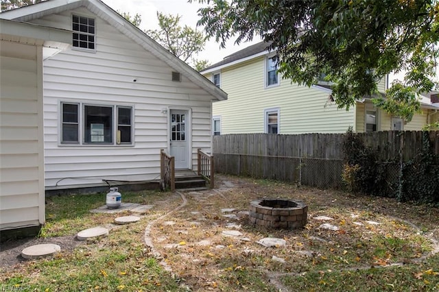 back of house with a fire pit