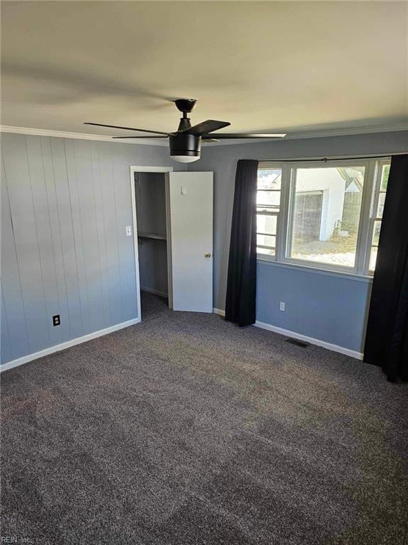 unfurnished bedroom with dark colored carpet and ceiling fan