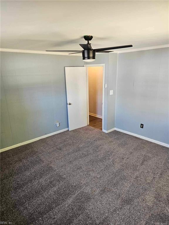 carpeted empty room with crown molding and ceiling fan