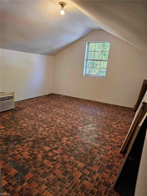 bonus room with lofted ceiling and a wall unit AC