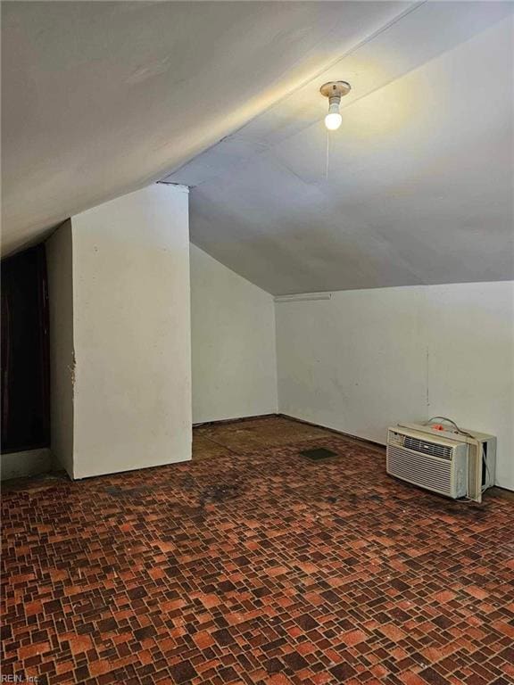 bonus room featuring a wall mounted AC and lofted ceiling