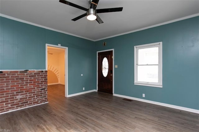 foyer featuring dark wood-type flooring, ceiling fan, crown molding, and brick wall