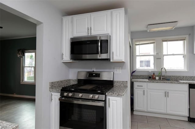 kitchen featuring white cabinetry, stainless steel appliances, and light stone counters