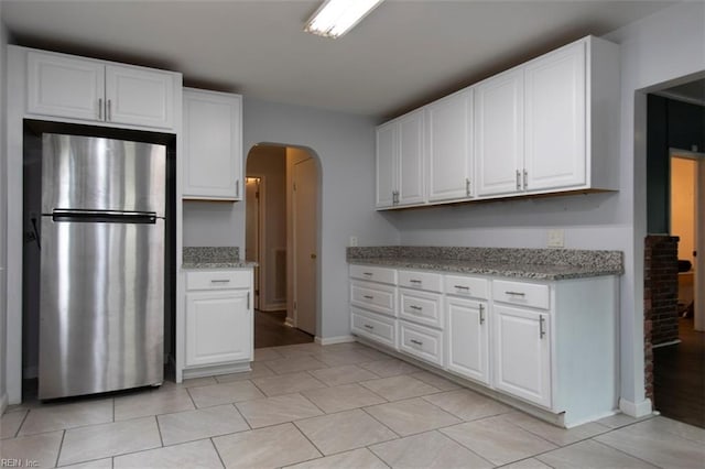 kitchen with white cabinets and stainless steel fridge