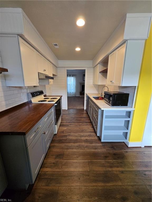 kitchen featuring butcher block counters, white cabinetry, sink, dark hardwood / wood-style floors, and electric stove