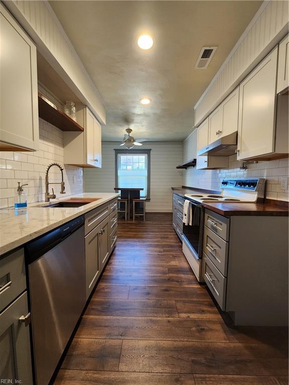 kitchen featuring ceiling fan, sink, dark hardwood / wood-style flooring, stainless steel dishwasher, and white range with electric cooktop