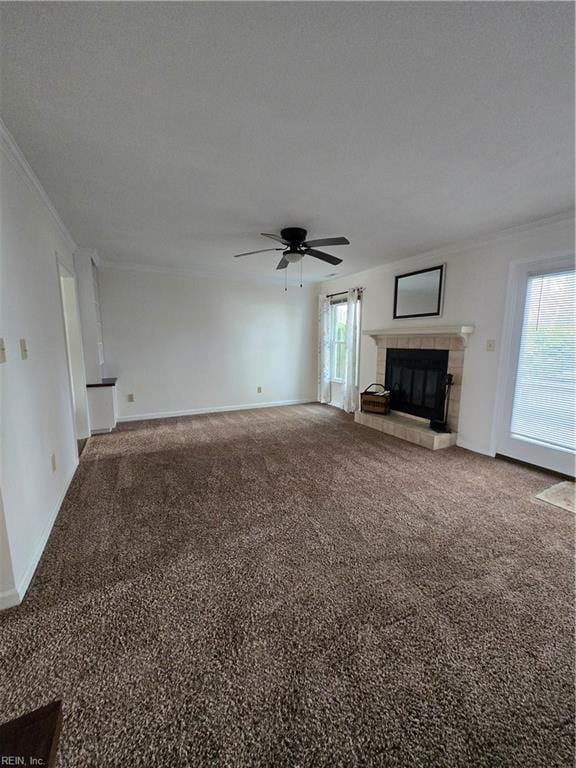 unfurnished living room featuring carpet flooring, ceiling fan, a textured ceiling, a tiled fireplace, and ornamental molding