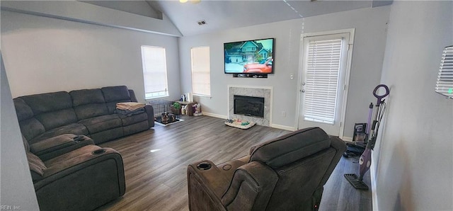 living room featuring wood-type flooring, a fireplace, a wealth of natural light, and vaulted ceiling