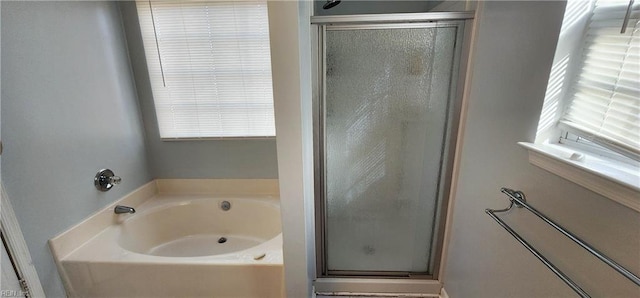 bathroom featuring plenty of natural light and independent shower and bath