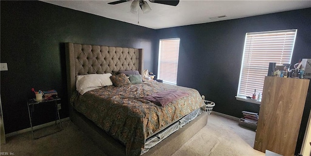 bedroom featuring multiple windows, ceiling fan, and light carpet