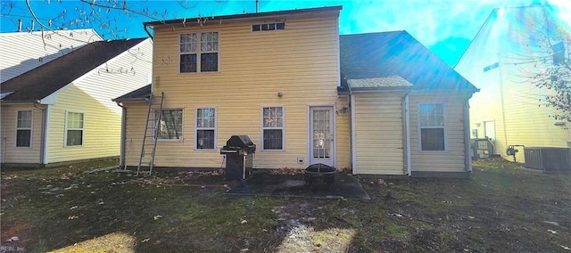 back of house featuring central air condition unit and a yard