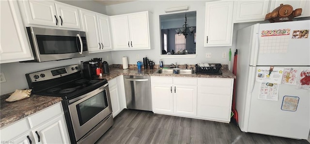 kitchen with stainless steel appliances, white cabinetry, a notable chandelier, and sink