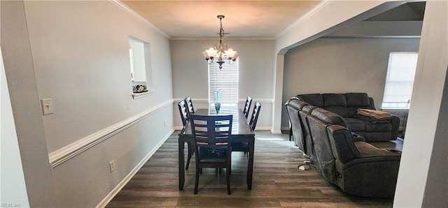 dining area with ornamental molding, dark hardwood / wood-style floors, and an inviting chandelier