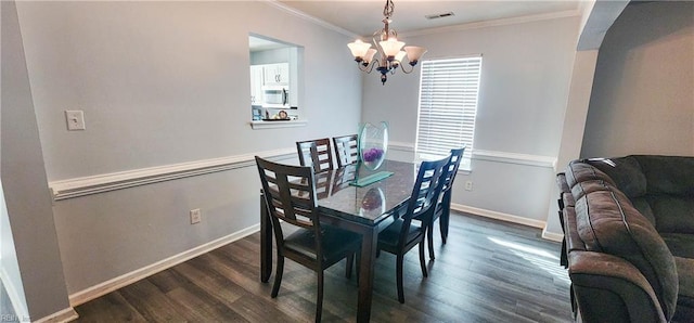 dining room featuring dark hardwood / wood-style floors, crown molding, and an inviting chandelier