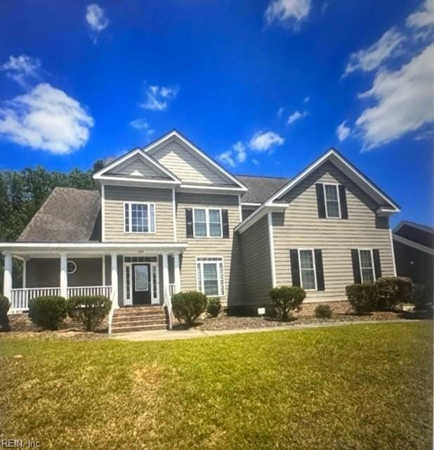 view of front of house with covered porch and a front lawn