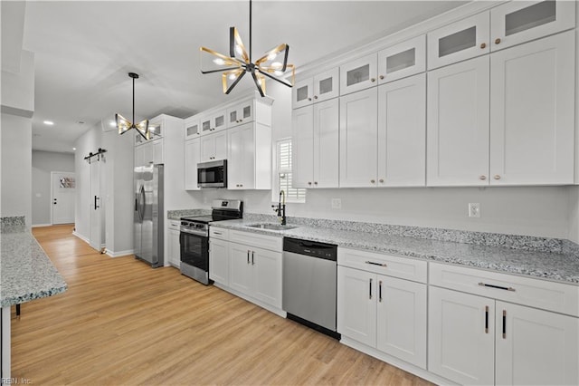 kitchen featuring white cabinetry, sink, a notable chandelier, pendant lighting, and appliances with stainless steel finishes