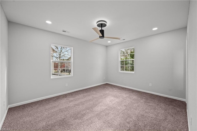 spare room with ceiling fan and carpet