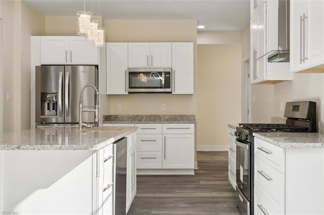 kitchen featuring white cabinets, hanging light fixtures, light stone countertops, dark hardwood / wood-style flooring, and stainless steel appliances