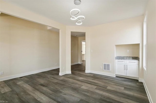 unfurnished dining area with dark wood-type flooring