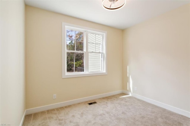 spare room featuring light colored carpet