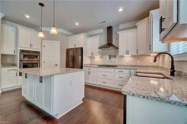 kitchen with a center island, white cabinets, sink, wall chimney exhaust hood, and appliances with stainless steel finishes