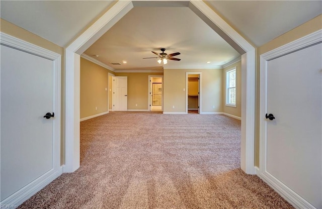 unfurnished living room with ceiling fan, crown molding, and light colored carpet