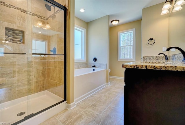 bathroom with plus walk in shower, vanity, and plenty of natural light