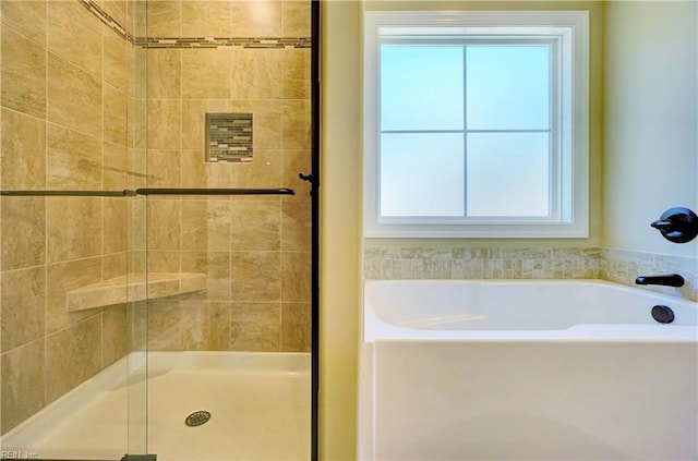 bathroom featuring independent shower and bath and a wealth of natural light