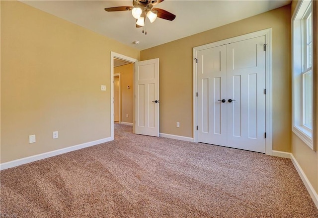 unfurnished bedroom featuring carpet, a closet, and ceiling fan