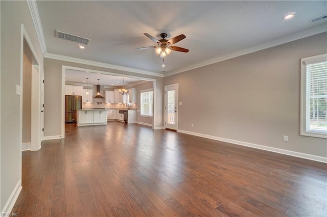 unfurnished living room with ceiling fan with notable chandelier, dark hardwood / wood-style flooring, and ornamental molding