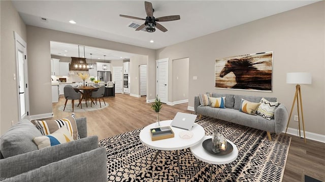 living room with hardwood / wood-style floors and ceiling fan