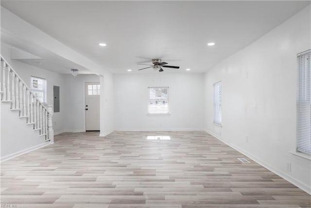 interior space featuring electric panel, light hardwood / wood-style flooring, and ceiling fan