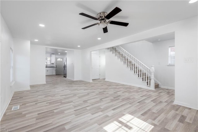 unfurnished living room featuring ceiling fan and light hardwood / wood-style floors