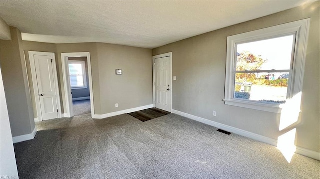 foyer with carpet and a textured ceiling