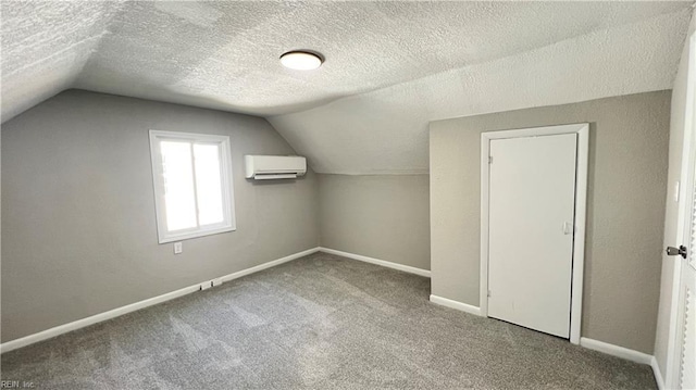 bonus room with carpet, lofted ceiling, an AC wall unit, and a textured ceiling