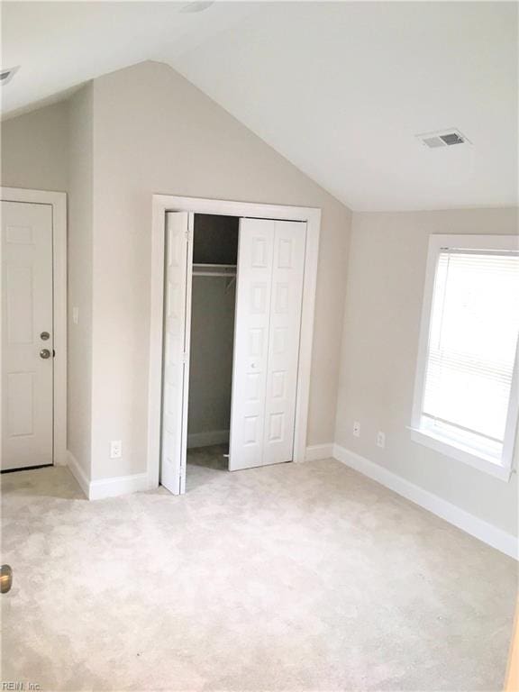 unfurnished bedroom with lofted ceiling and light carpet