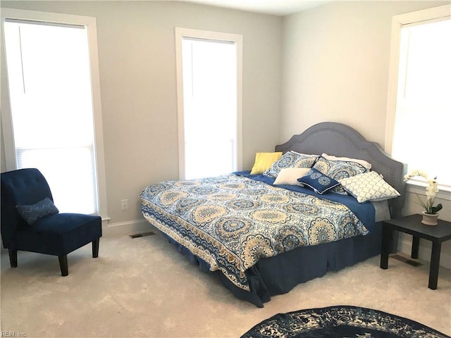 bedroom with multiple windows and carpet