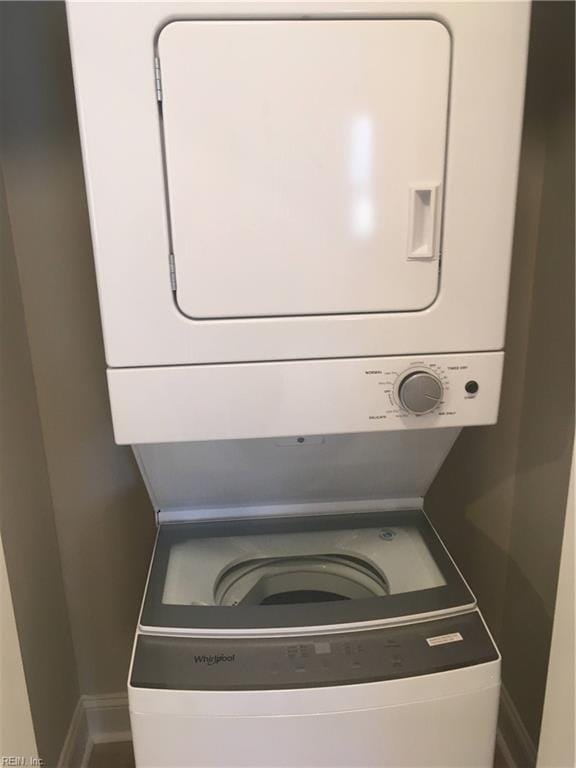 laundry room with stacked washing maching and dryer