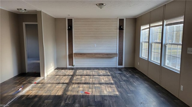 unfurnished room with dark wood-type flooring and a textured ceiling