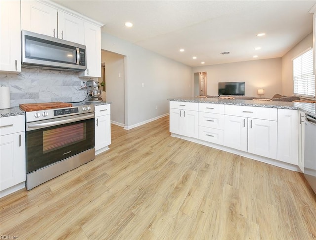 kitchen featuring white cabinetry, light stone countertops, stainless steel appliances, light hardwood / wood-style floors, and decorative backsplash