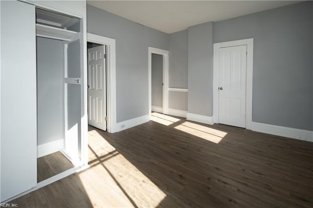 unfurnished bedroom featuring a closet and dark hardwood / wood-style flooring