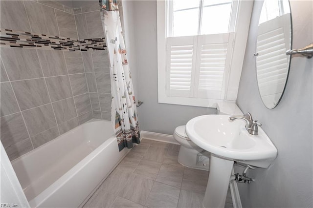 bathroom featuring tile patterned floors, a wealth of natural light, shower / tub combo with curtain, and toilet