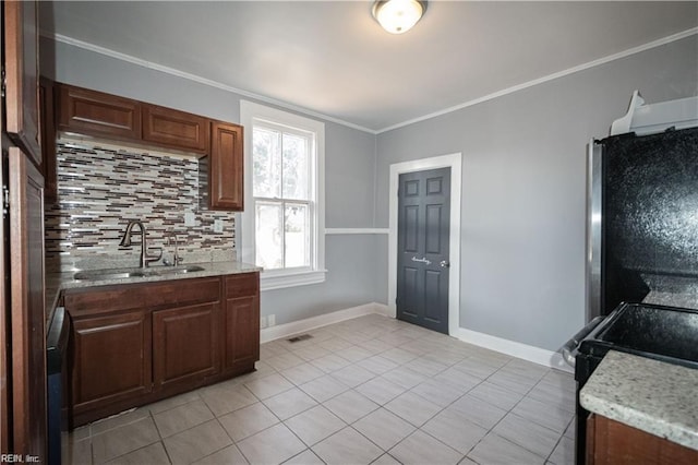 kitchen featuring stainless steel refrigerator, sink, backsplash, light tile patterned floors, and ornamental molding